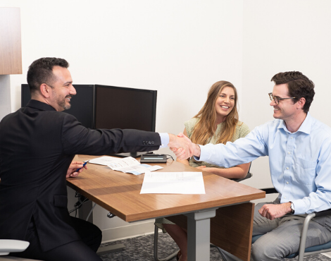 couple at desk with man shaking hands