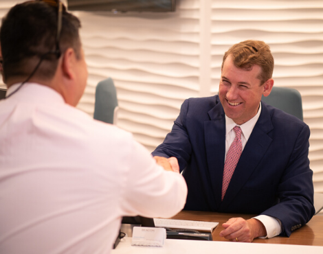 two men shaking hands at desk