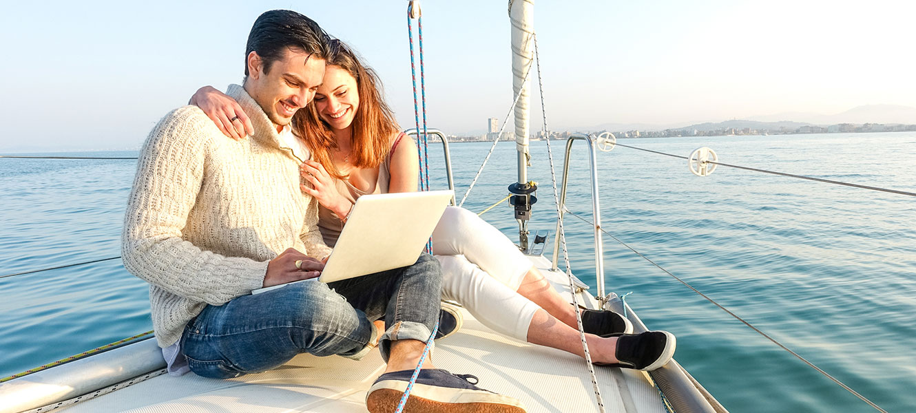 Couple using computer on boat