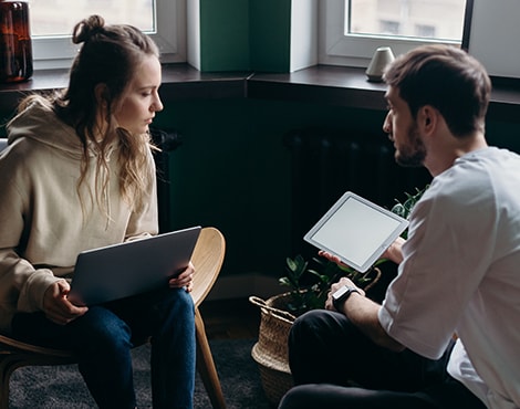 Young couple comparing notes on their devices