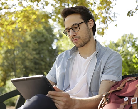 Man using tablet on park bench