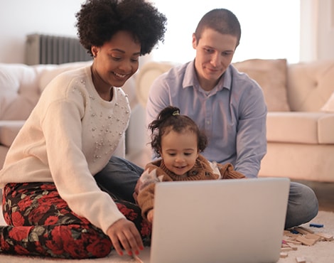 Young family looking at laptop in living room