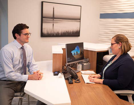 man and woman at desk talking